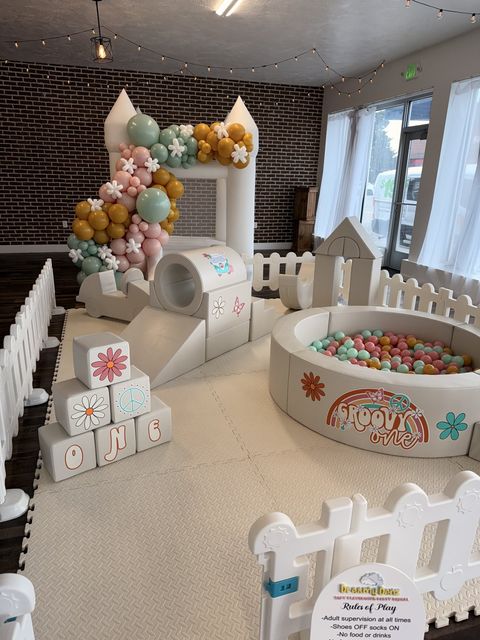 Indoor soft play set and ball pit with a rainbow balloon garland