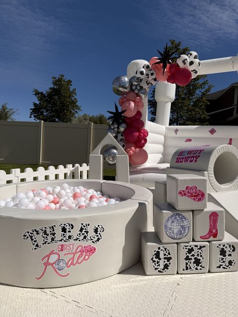 Texas rodeo-themed ball pit, soft play blocks, and bounce house with balloon garland