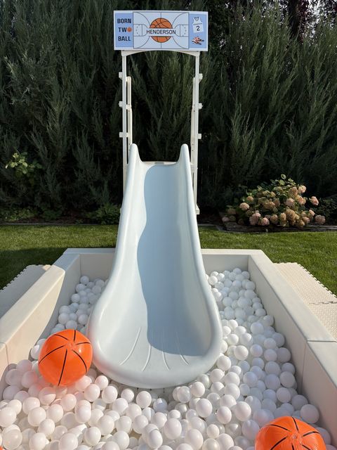 Close-up of a slide into a ball pit with basketballs